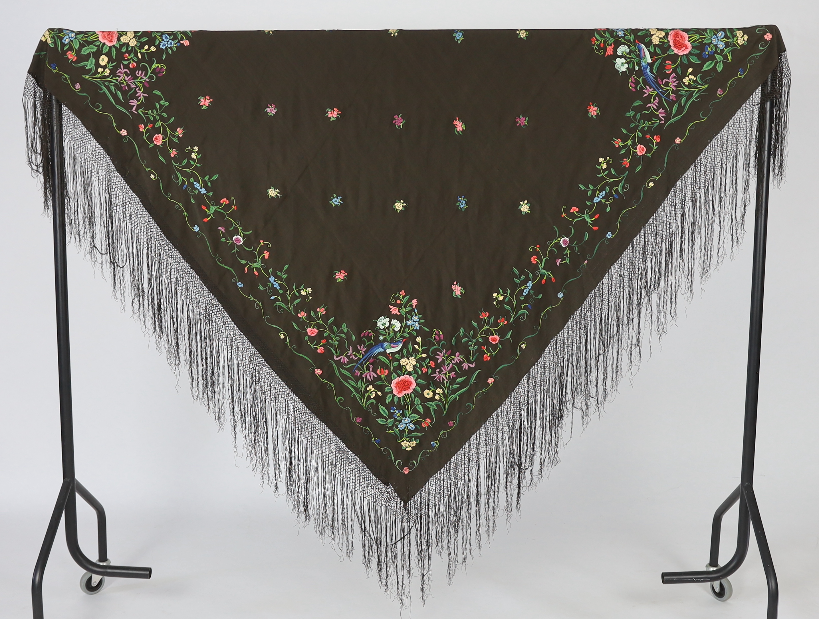 A Chinese silk shawl, circa 1900, embroidered with polychrome threads with birds and flowers against a black silk ground, 164cm sq.